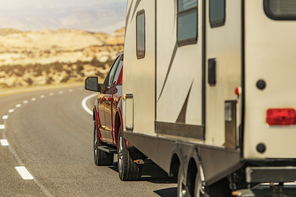 Vue arrière d'un pick-up avec roulotte sur route