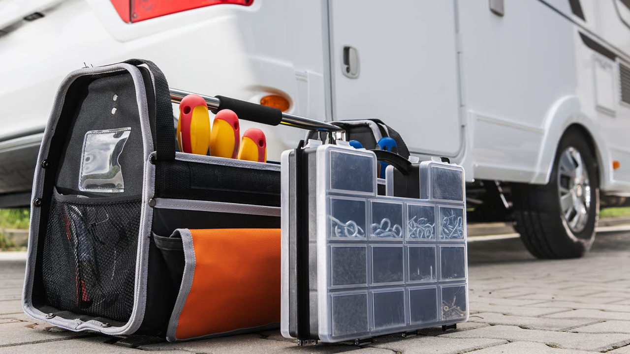 Des boîtes à outils à côté d'une roulotte pour entretien.
