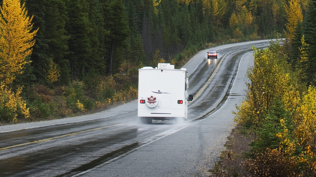 Vue arrière d'une roulotte sur route dans l'ouest canadien un jour de pluie